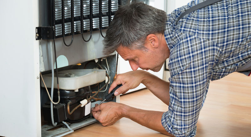 Man Repairing a Fridge