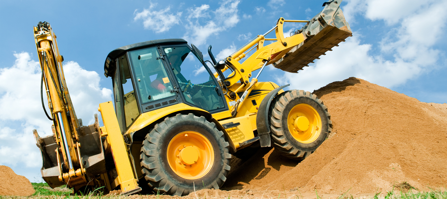 Used Backhoe Loader Digging in Dirt Pile