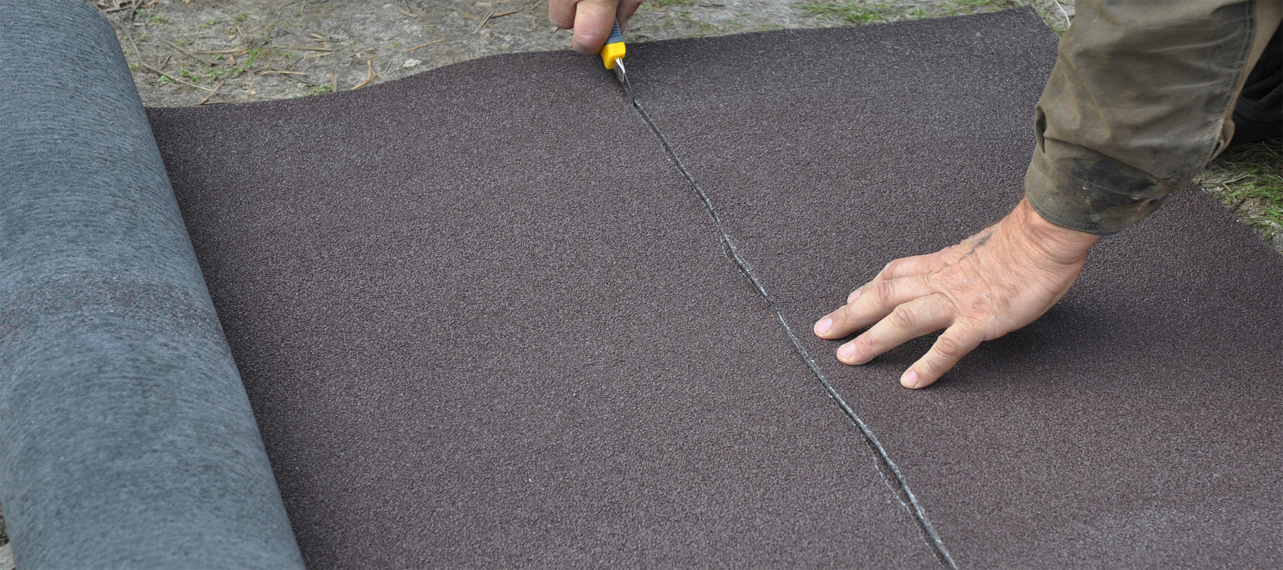 Construction Worker Cutting Roll Roofing